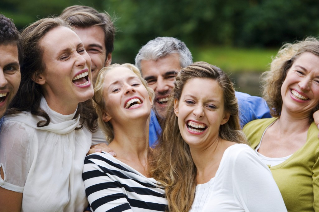 A group of men and woman laughing and smiling