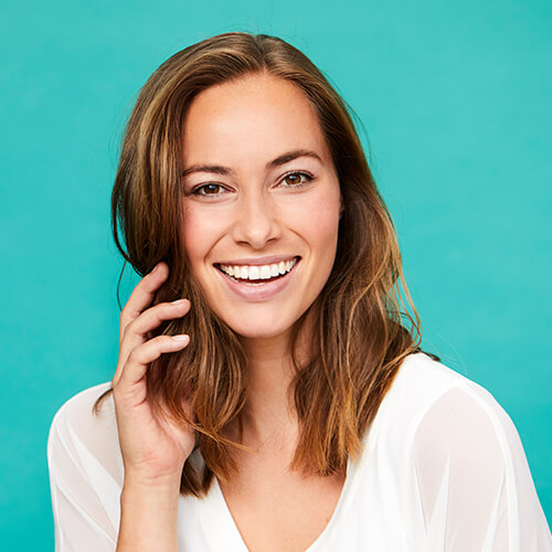 A woman smiling with a blue background